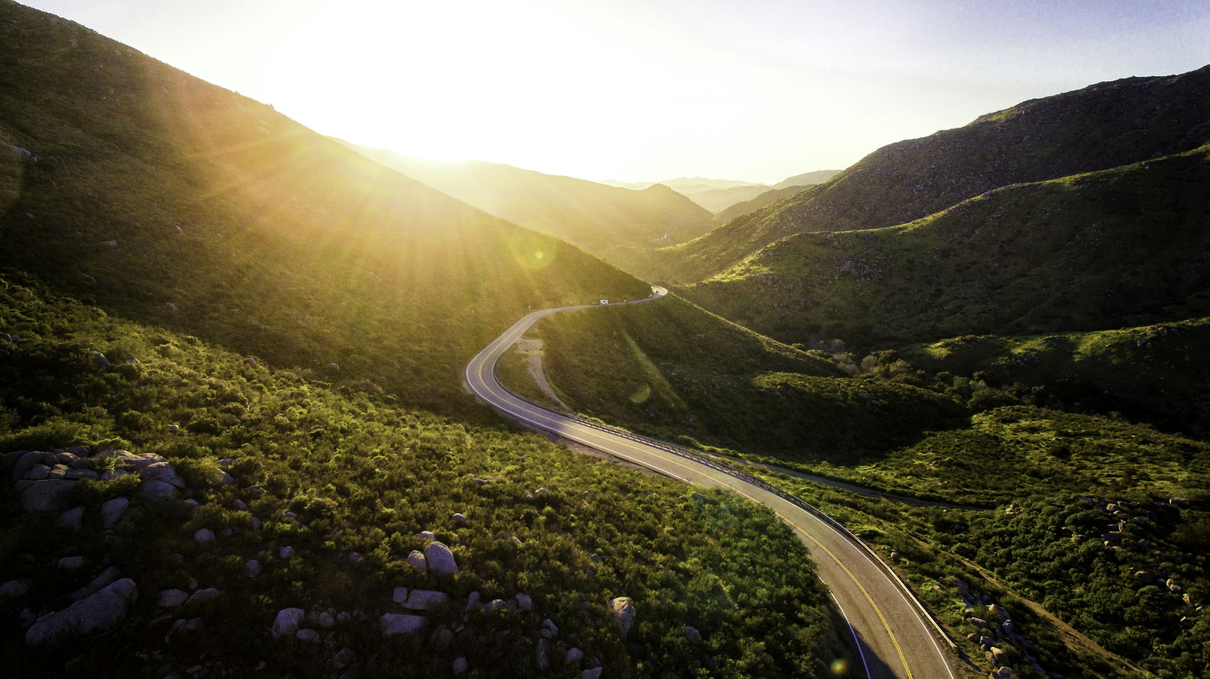 A quiet road curving toward the horizon at sunrise